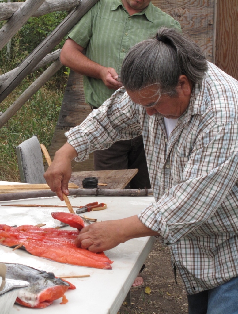 An Elder prepares to cook fish on an open fire